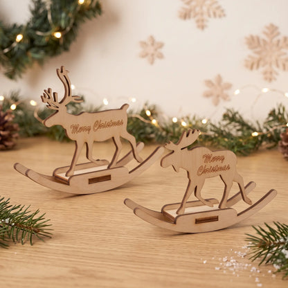 Two rocking reindeer figurines made of laser cut plywood standing on wooden table with holiday lights.