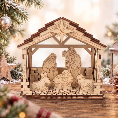 Laser cut plywood Nativity scene with Holy Family figures on snowy table near Christmas pine branches and candle lantern.