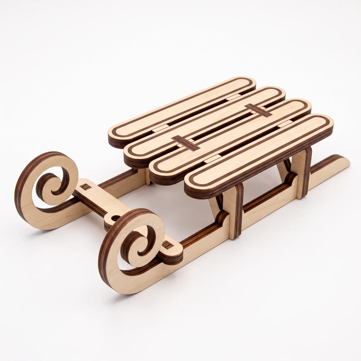 Perspective view of assembled laser cut plywood vintage holiday sled with slotted runners on white backdrop