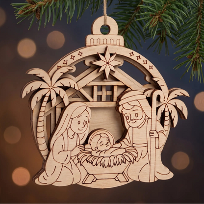 Layered laser cut plywood nativity scene bauble ornament hanging from pine bough against warm holiday bokeh lights