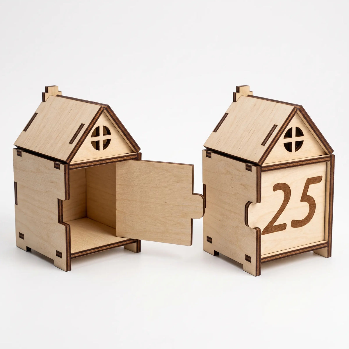 Pair of miniature laser cut plywood house gift boxes showing closed numbered front and open interior compartment.