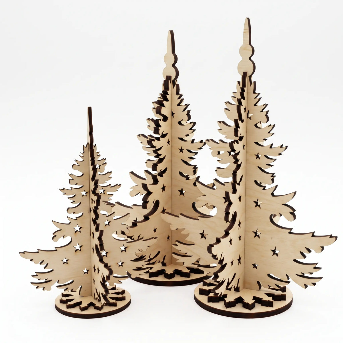 Set of three standing laser cut plywood Christmas trees in different sizes isolated on white background.