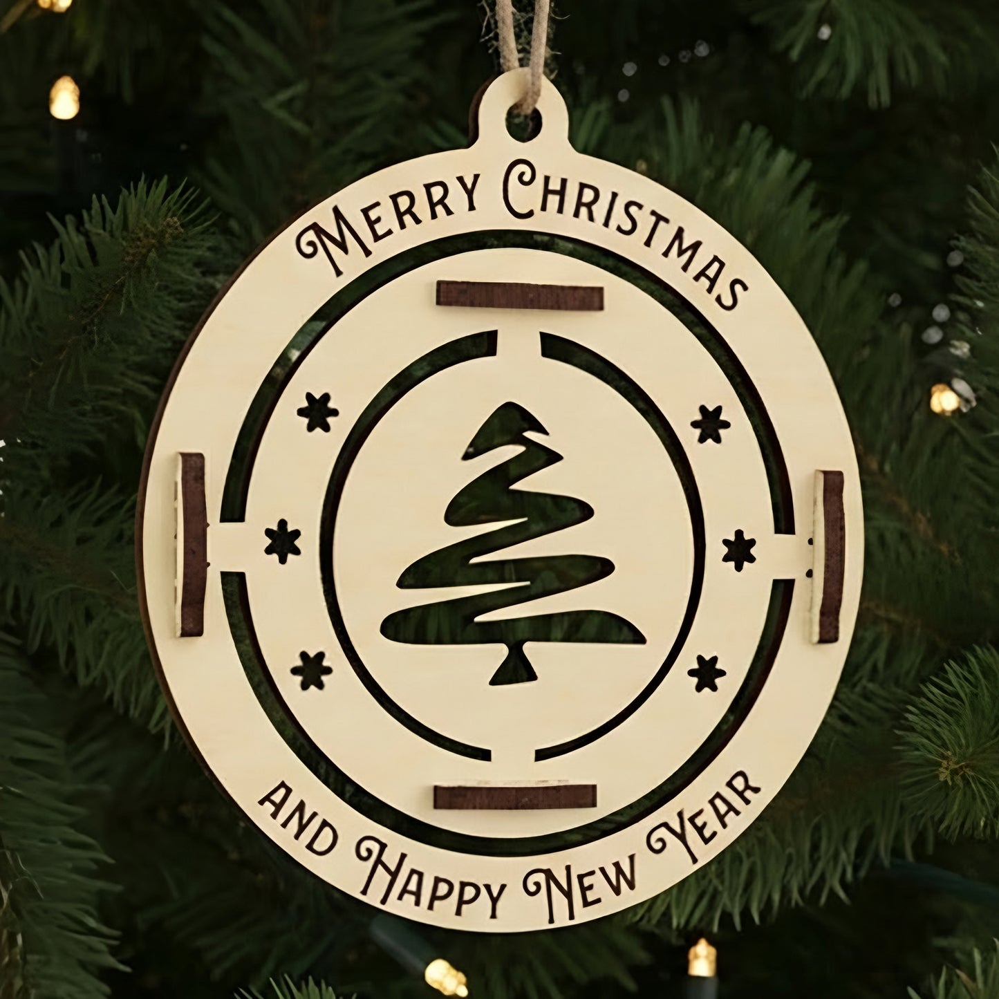 Laser cut wooden Christmas tree toy Happy New Year with a spinning stylized Christmas tree silhouette in the center and "Merry Christmas and Happy New Year" engraving, displayed against a warm lighted Christmas tree background.