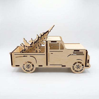 Side profile of assembled laser cut plywood pickup truck carrying wooden pine tree cutout on white background.