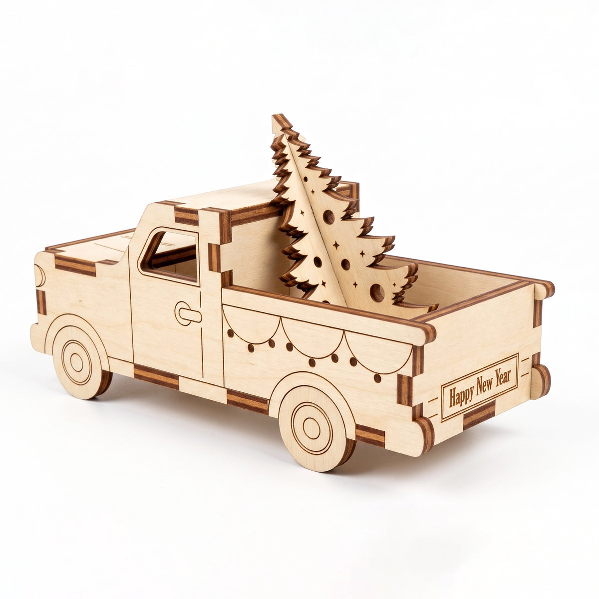 Rear three-quarter view of laser cut plywood pickup truck carrying wooden pine tree on white background