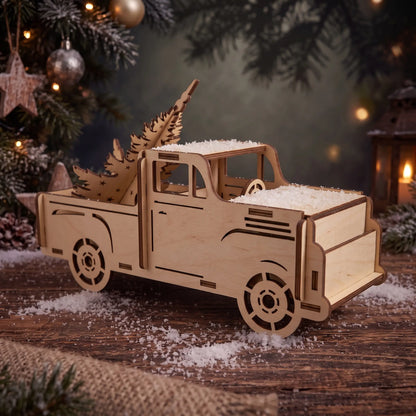 Laser cut plywood holiday pickup truck carrying wooden pine tree on snowy rustic wood table near candle lantern.