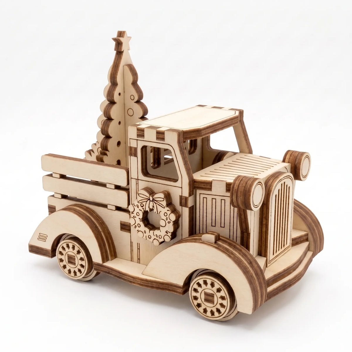 Front three-quarter view of 3D laser cut plywood vintage holiday truck carrying Christmas tree on plain white background.