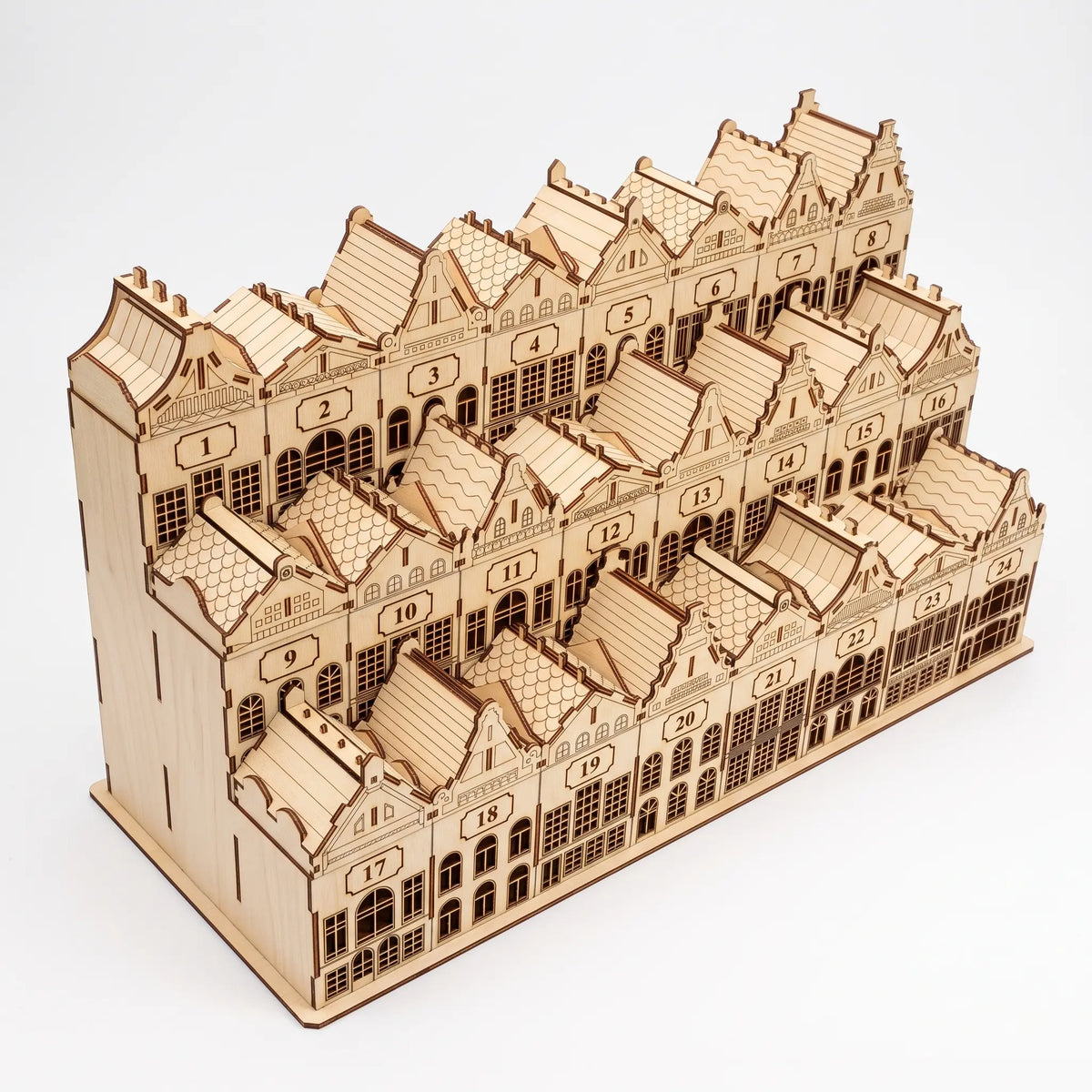 High-angle perspective view of assembled laser cut plywood townhouse advent calendar with gabled roofs on white.