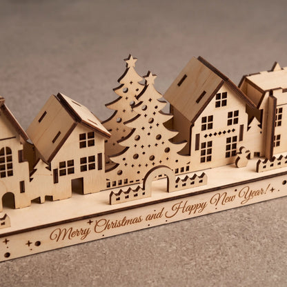 Close perspective of laser cut plywood holiday town houses and trees on engraved Happy New Year stand.