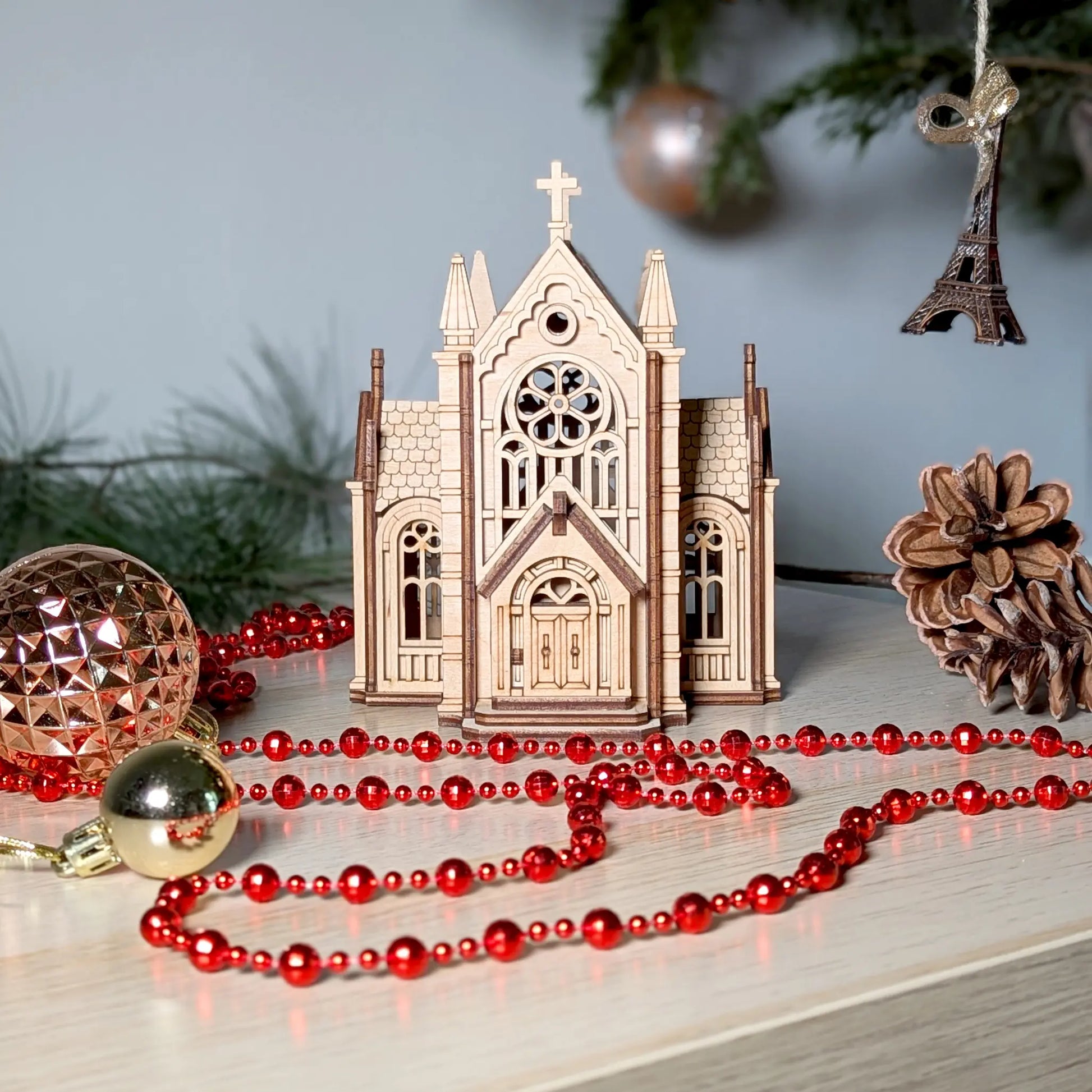 A straight eye-level front view of an assembled holiday church building model crafted from layered laser cut plywood.