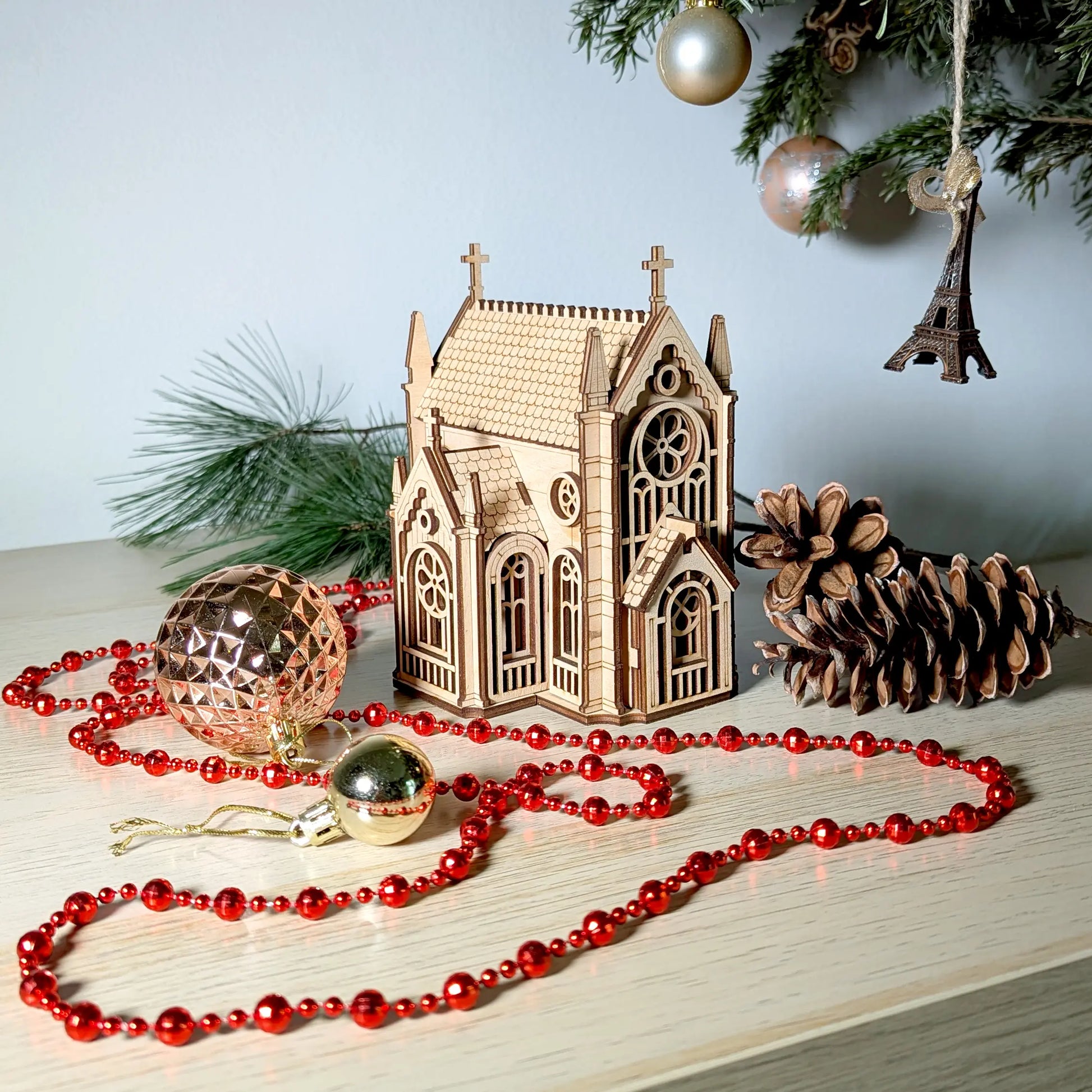 Beautiful high-angle holiday lifestyle shot of a miniature cathedral centerpiece beautifully made of laser cut plywood.