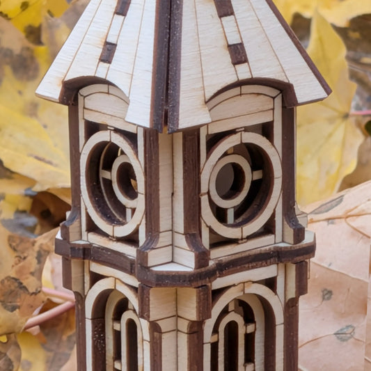 Macro close-up shot focusing on the intricate dial face and layered upper architecture of a laser cut plywood clock tower.