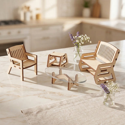 Miniature furniture set made of laser cut plywood including an armchair, bench, stool, and coffee table with a clear top. Pieces feature modern geometric cutouts and dark burnt edges, displayed on a marble counter with small lavender bouquets.