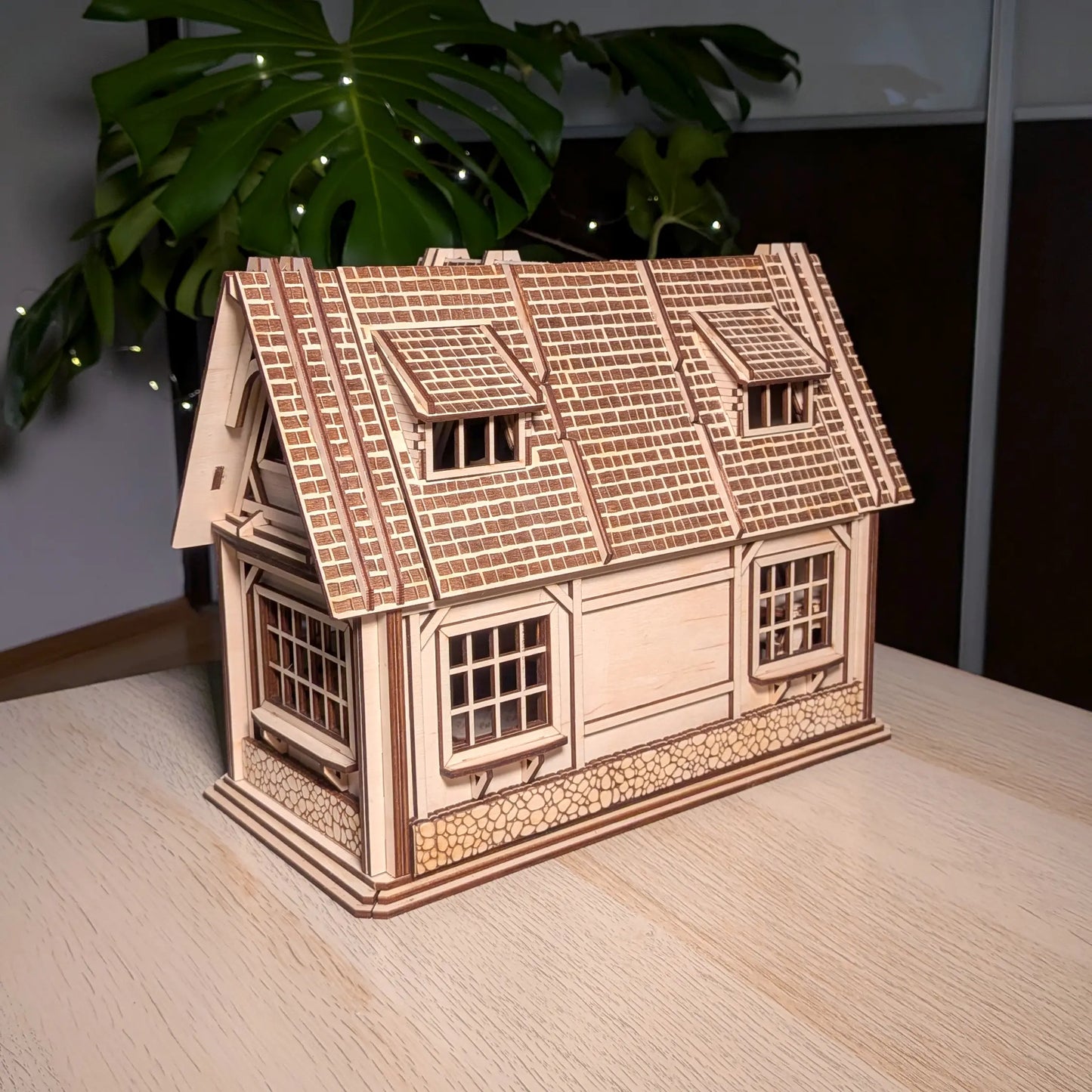 Closed exterior view showing the back and side walls of a miniature country house with shingle roof made of laser cut plywood.