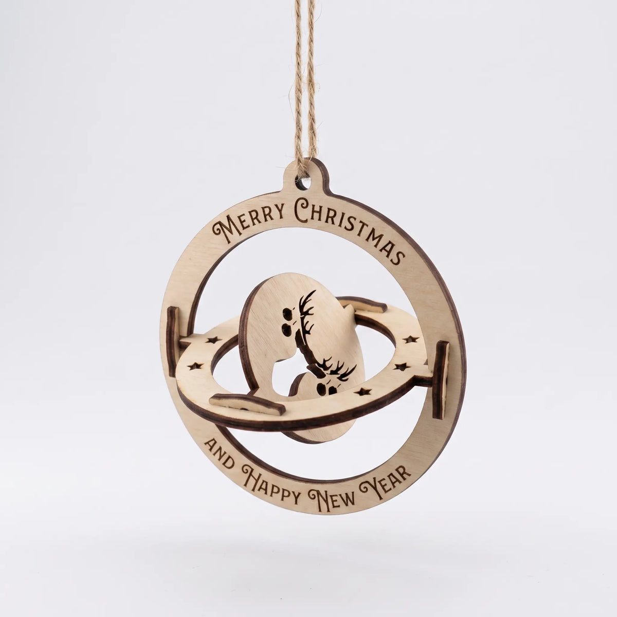 Angled view of 3D rotating laser cut plywood kinetic bauble with deer silhouette cutout isolated on plain white.
