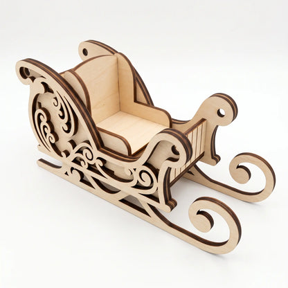 High angle perspective of assembled laser cut plywood Christmas sleigh with curved runners on light base.