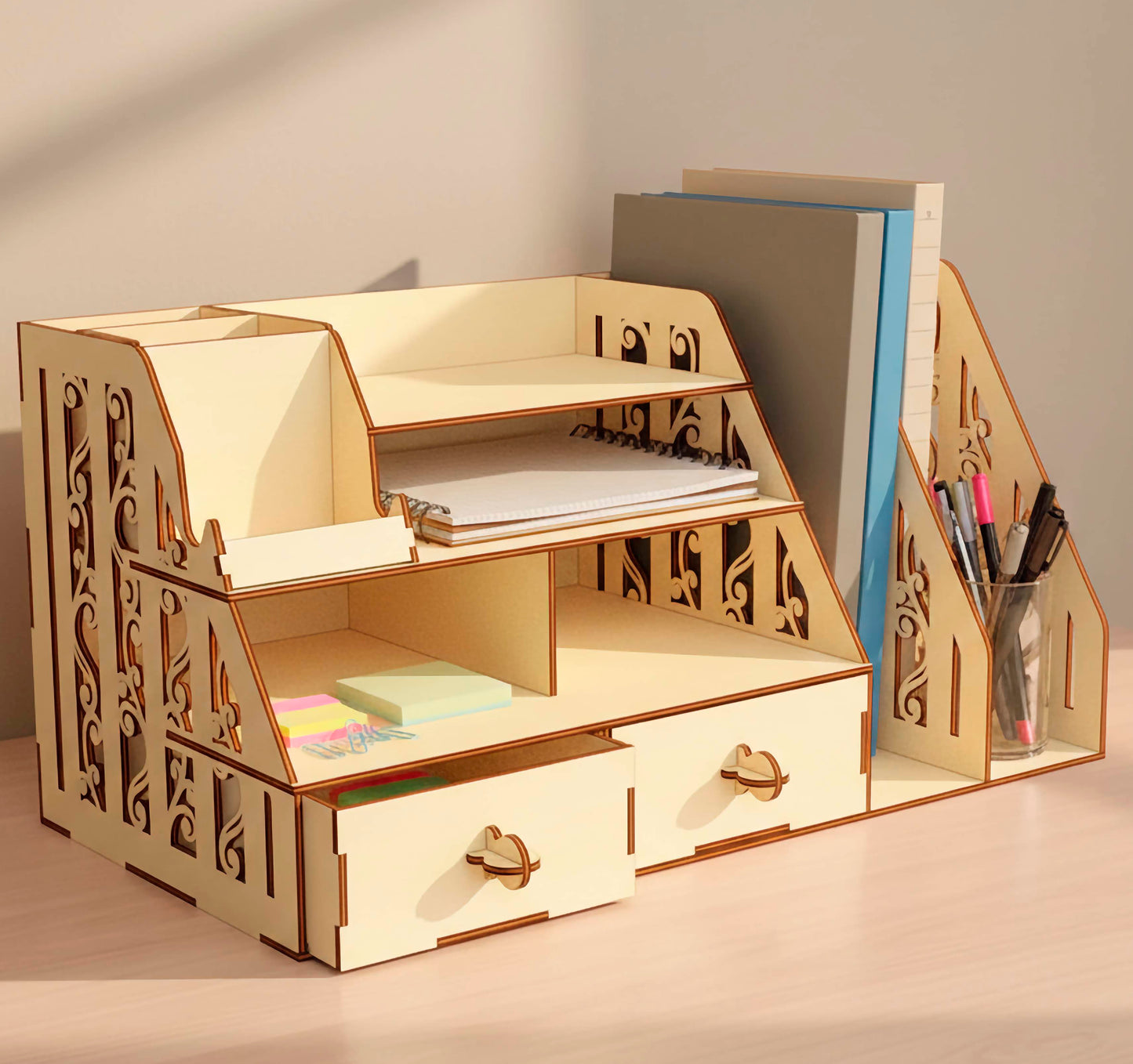 Front view of a multi-tier laser cut plywood desk shelf. Organized with notebooks, sticky notes, and folders. Highlights the precise interlocking joinery and decorative laser-etched scrollwork on the side support walls.