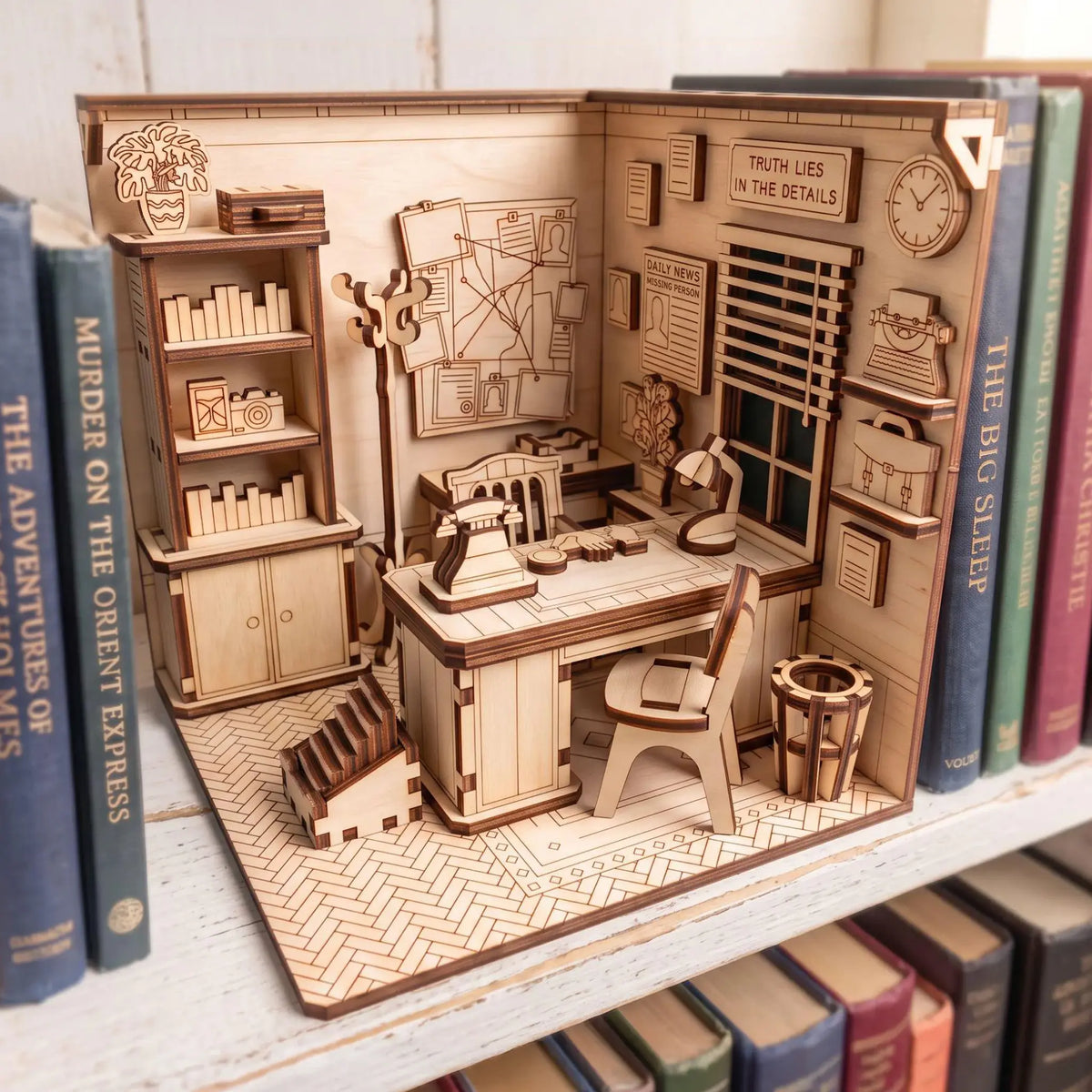 Laser cut plywood detective office book nook standing on white bookshelf surrounded by mystery novels and detective books.