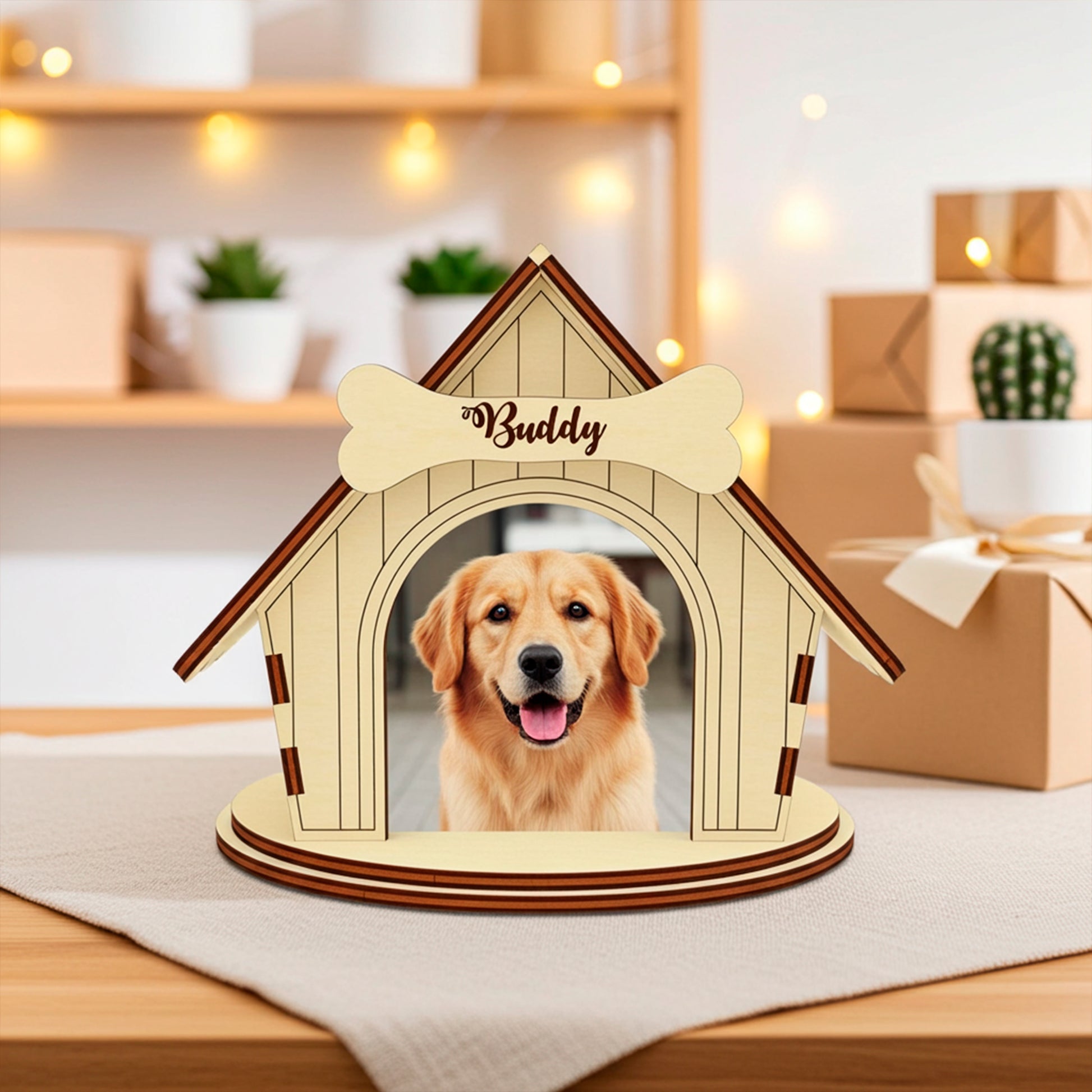 Laser cut wooden plywood dog house photo frame made of light-colored wood. The house features a personalized bone name tag etched with the name "Buddy" above the entrance, framing a  puppy's smiling face. The wooden base and roof edges have contrasting dark brown layers.