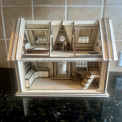 Rear view of a real laser cut plywood dollhouse model on a dark countertop showing rooms filled with tiny furniture.