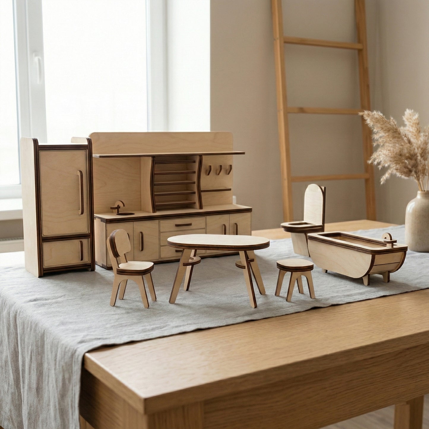 Miniature kitchen and bathroom furniture crafted from laser cut plywood. Features a tall refrigerator, a kitchen unit with a sink, a dining table with chairs, and a bathtub. The clean wooden edges and realistic details create a modern look.