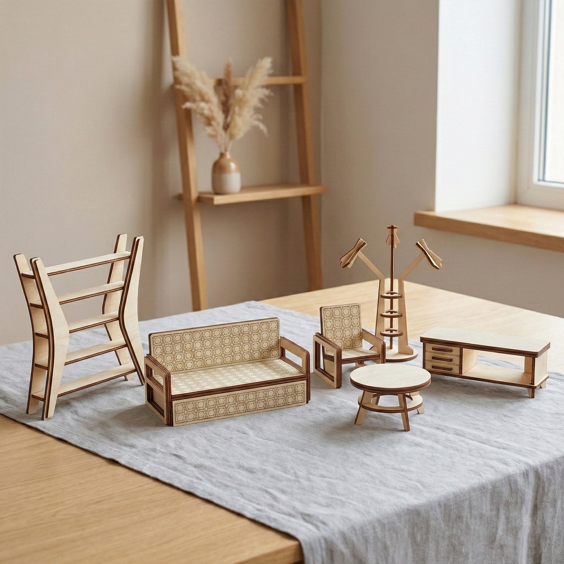 Laser cut plywood dollhouse living room furniture. Includes a modern sofa and armchair with geometric engravings, a round coffee table, a TV stand, and a unique floor lamp. Displayed in a bright interior with pampas grass in the background.