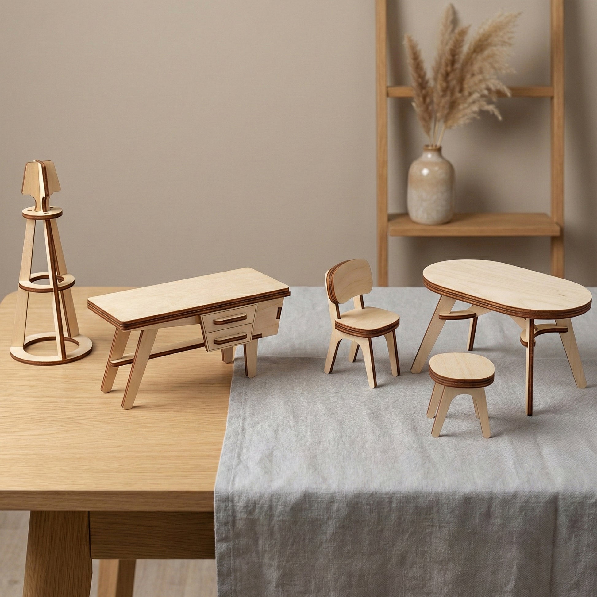 A minimalist wooden desk, a dining table with a chair and stool, and a tall lighthouse-style lamp made of laser cut plywood. The set demonstrates high-quality craftsmanship and a smooth birch finish on a light wood tabletop.