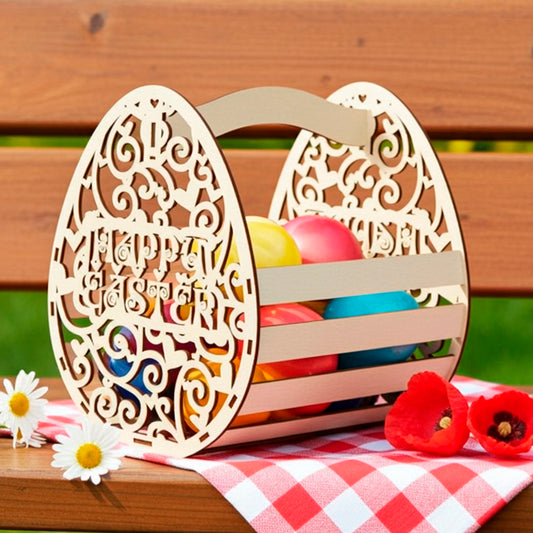 Laser cut plywood wooden Easter basket shaped like a decorative egg with "Happy Easter" text cutout, filled with colorful painted eggs and standing on a picnic bench with a red checkered napkin, next to daisies and red poppies