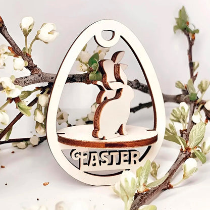 Laser cut plywood wooden Easter egg ornament with a detailed cutout of a playful bunny standing above the etched word "EASTER," framed by white blooming spring tree branches on a white background