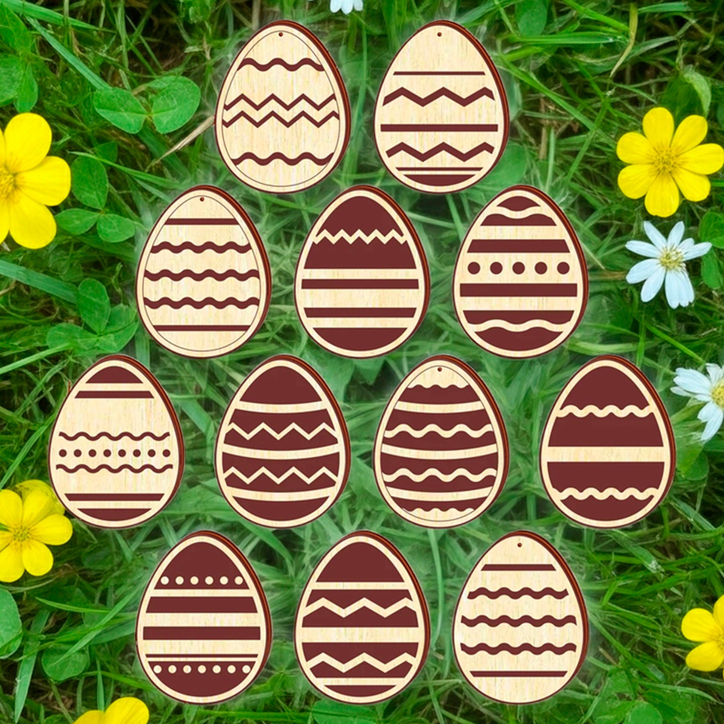 A set of twelve light brown laser cut wooden plywood Easter egg ornaments, each engraved with a different geometric or floral pattern, lying on a bright green grass background among yellow buttercups and small pink flowers