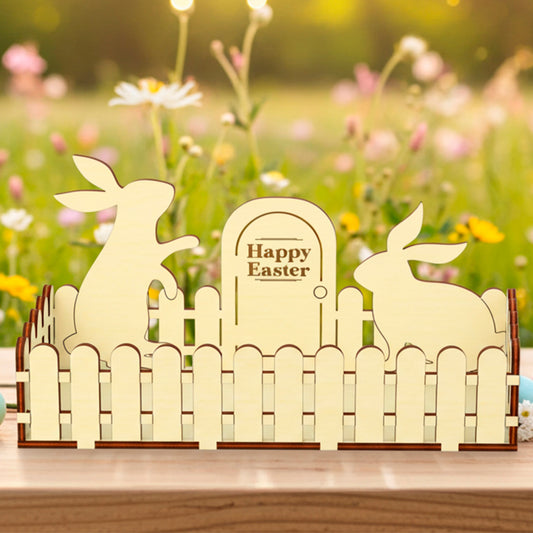 Laser cut  plywood wooden Easter fence decoration featuring two bunny silhouettes and a sign that reads "Happy Easter," styled outdoors on a table with colorful eggs and a wildflower background