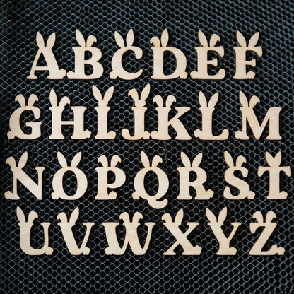 Wooden laser cut letters A to Z on a black mesh background