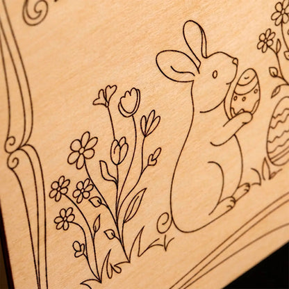 Macro detail of a laser cut plywood surface featuring an engraved Easter bunny and spring flowers design.