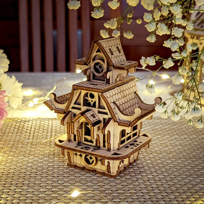 Cozy evening shot of an elven laser cut plywood house ornament sparkling with golden fairy lights and floral accents.
