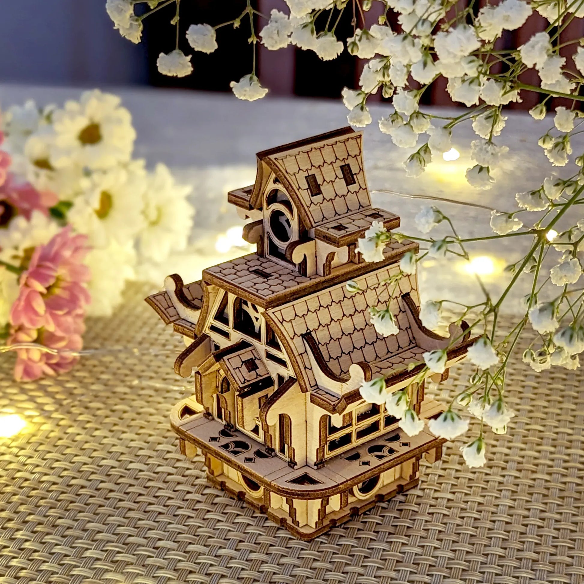 Miniature fairy house, laser cut plywood, staged with baby's breath flowers. A detailed wooden home for magical decor.