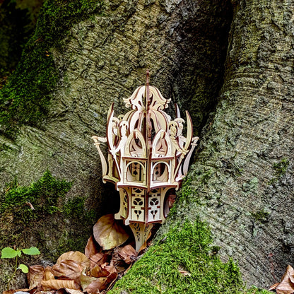 Medium shot of an intricate laser cut plywood elven dice tower lantern standing in a hollow root with dry autumn leaves.