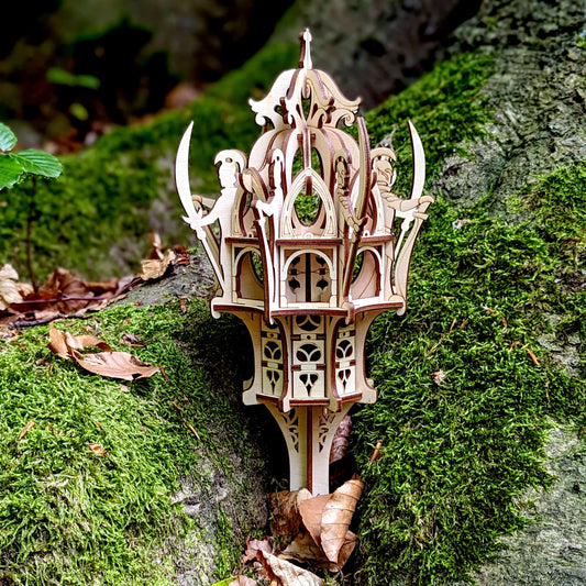Tight close-up of a laser cut plywood elven structure with tiny guards holding swords, placed on vibrant green moss.