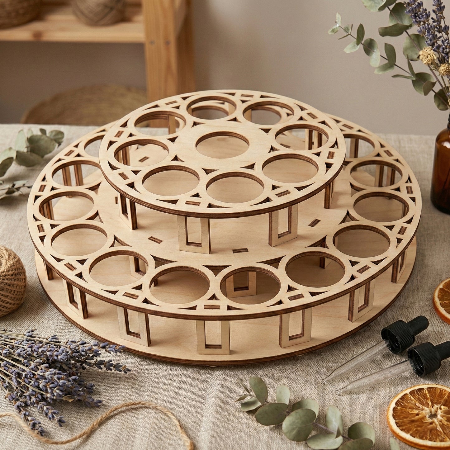 Wooden plywood tiered retail riser for essential oils featuring decorative rectangular cutouts and circular slots for bottle organization, styled on a linen cloth with dried lavender and eucalyptus.