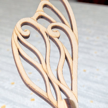 Detailed view of a fairy bee wing made from laser cut plywood, featuring elegant curved lines and smooth wooden finish