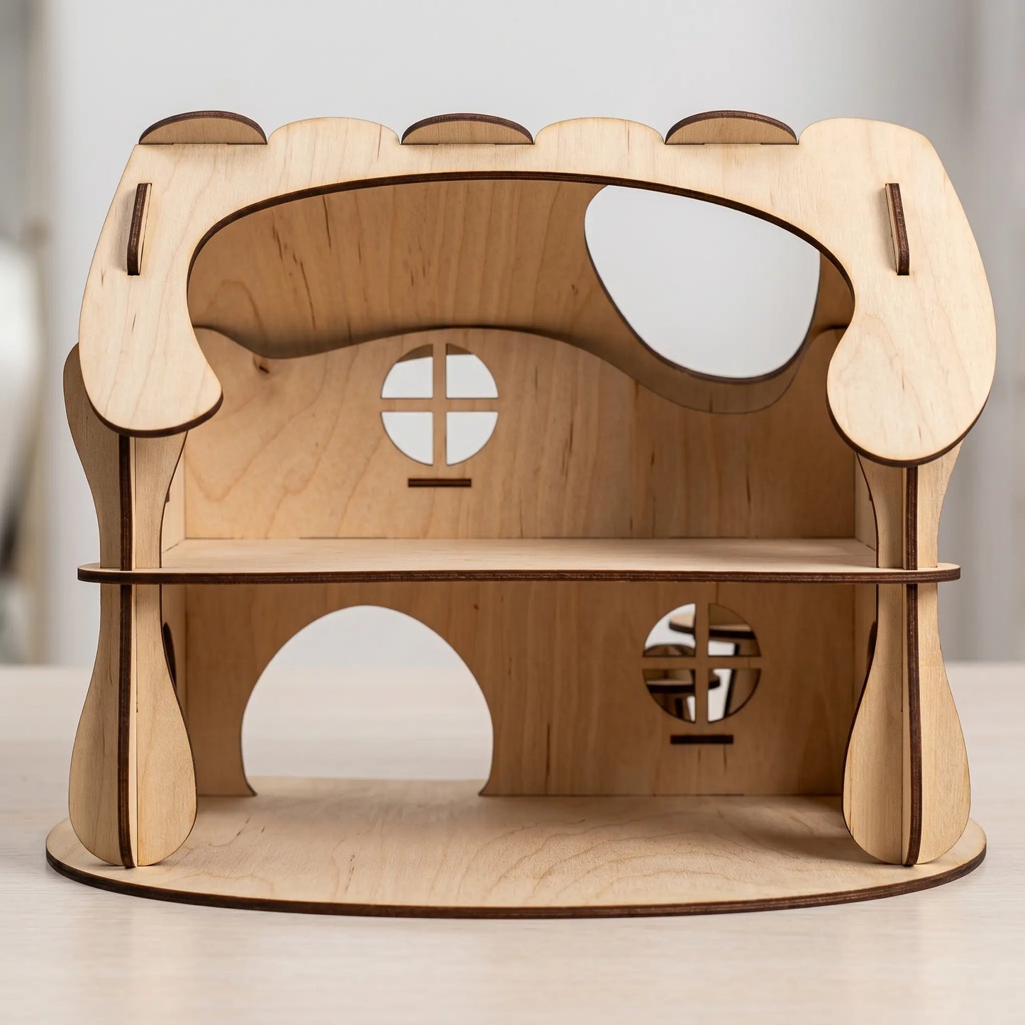 Wooden laser cut dollhouse house with geometric design on a neutral background