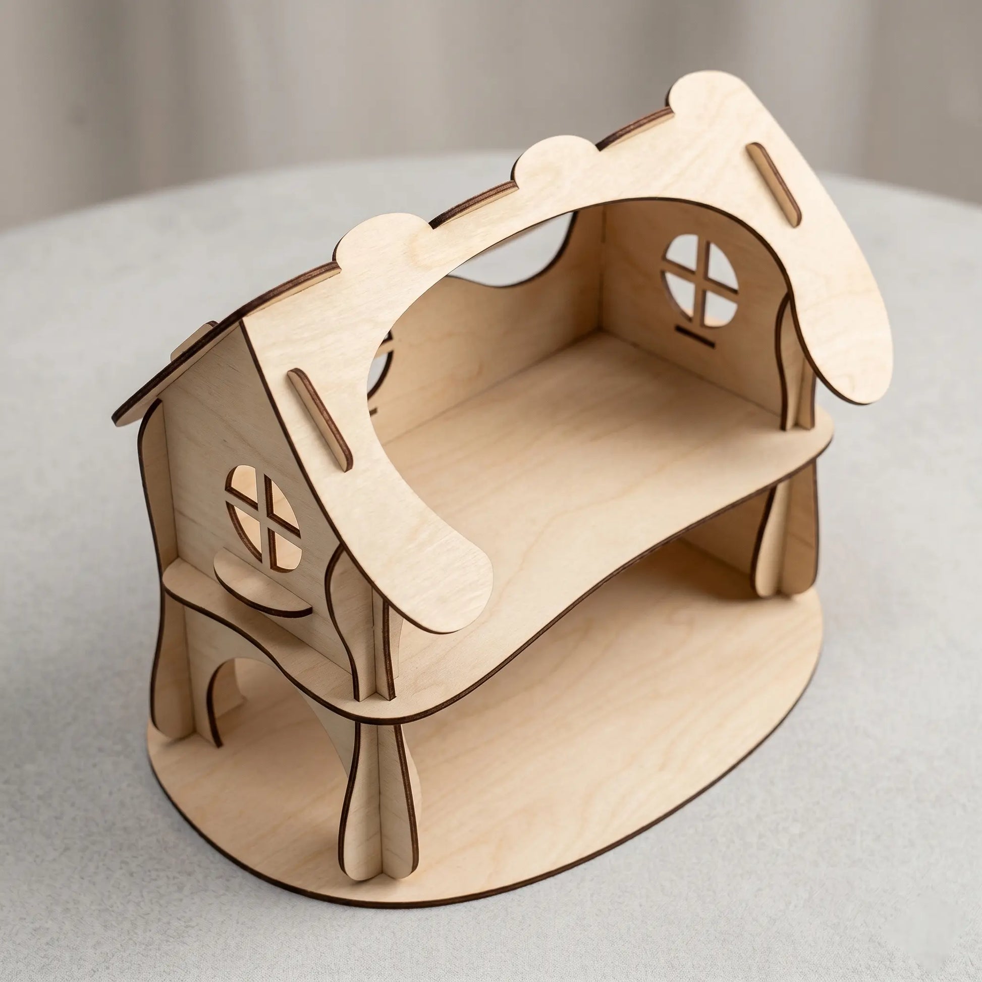 Wooden dollhouse laser cut model on a light gray surface