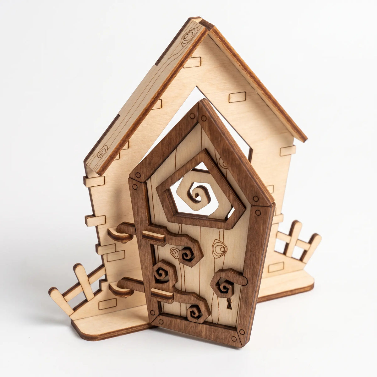 Rustic fantasy laser cut plywood fairy door set with asymmetric frame, decorative hinges, and miniature fence on white background.