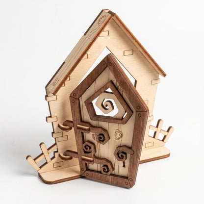 Rustic fantasy laser cut plywood fairy door set with asymmetric frame, decorative hinges, and miniature fence on white background.