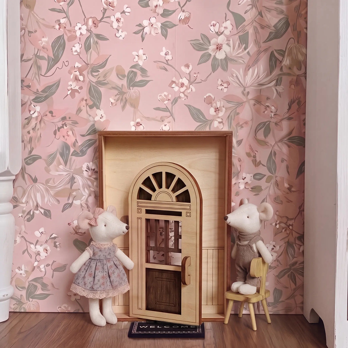 Open architectural laser cut plywood fairy door model placed in dollhouse room with floral wallpaper beside toy mice.