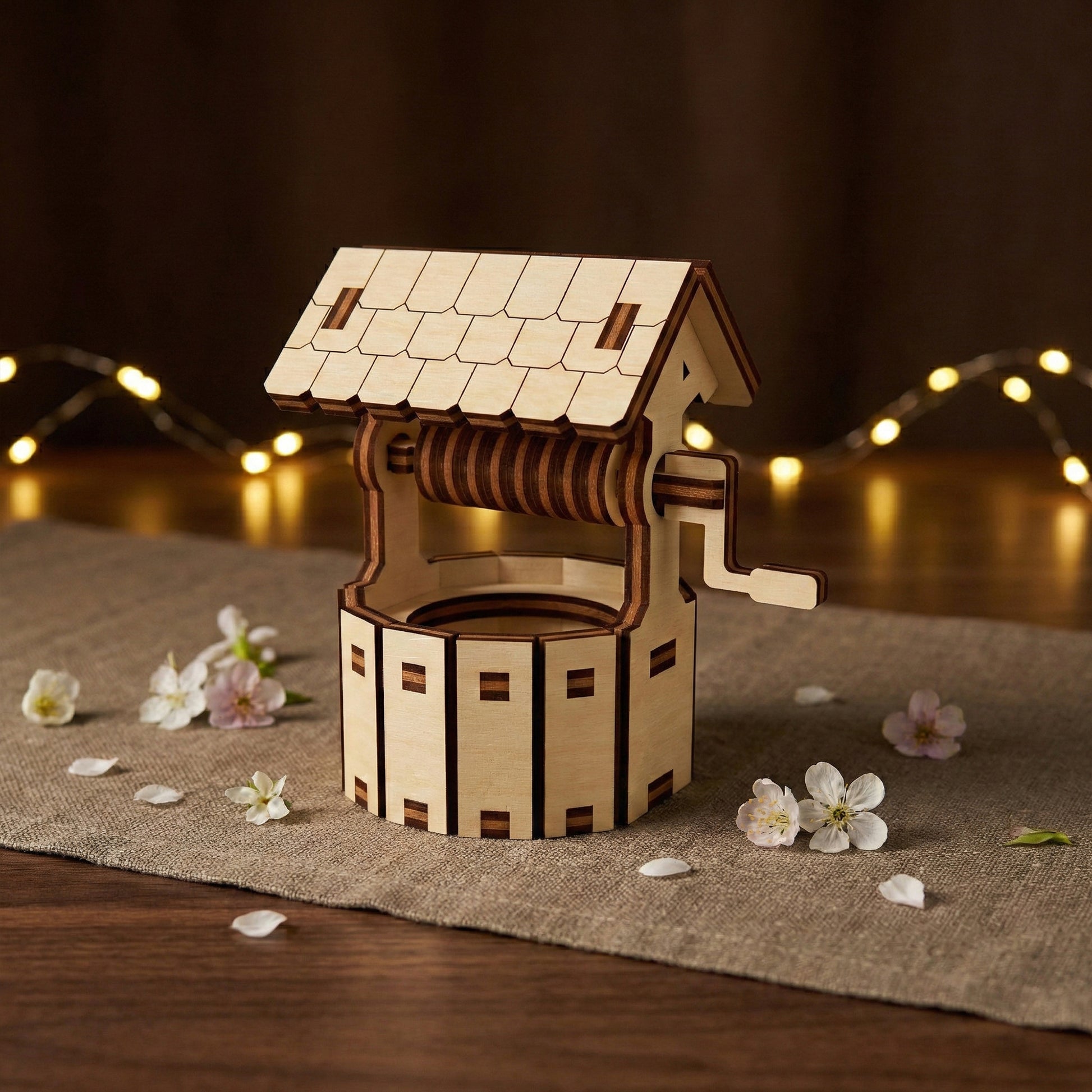 Decorative wishing well for a fairy garden, made from laser cut plywood. Features a tiled-effect roof and a functional-looking crank handle. Detailed wood assembly showing high-precision craftsmanship and realistic textures.