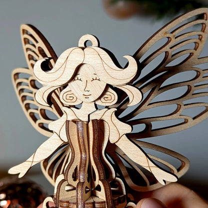 Close-up portrait of an elegant 3D laser cut plywood fairy ornament showing delicate face engraving and wing structure.