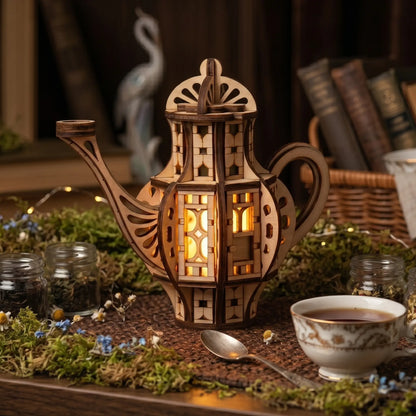 Glowing wooden teapot fairy house with LED lights inside, styled as whimsical cottagecore shelf decor with moss, tea cup, books, and dried flowers.