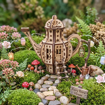 Miniature teapot fairy house laser cut design displayed in a magical fairy garden scene with moss, mushrooms, flowers, stones, and tiny garden accessories.