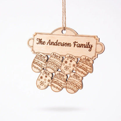 Angle view of natural laser cut plywood family mitten ornament with seven engraved names hanging on plain white background.