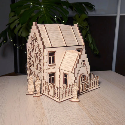 Three-quarter view of a laser cut plywood model house with three miniature wooden family figures placed around the yard.